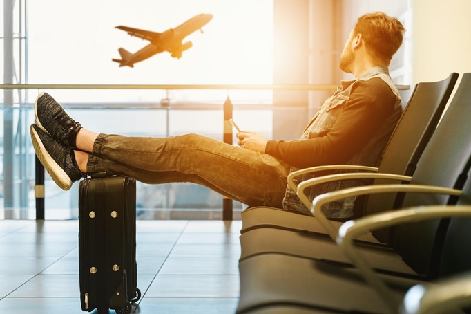 A picture of a vacationer sitting in the airport waiting to leave on their vacation with Royal Holiday Vacation Club.